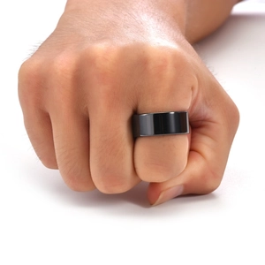 Close-up of a wide minimalist black ceramic ring with a polished mirror finish on hand
