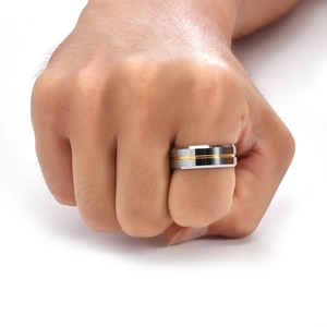 Detail of 8mm wide tungsten steel ring with gold groove worn on a male finger