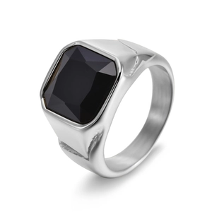 Macro detail of men's silver signet ring with a large faceted square black gemstone