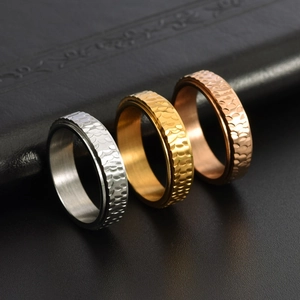 Close-up of hammered stainless steel spinner rings in silver, gold, and rose gold finish