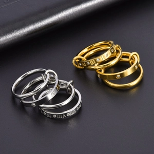 Detailed macro view of triple-linked titanium steel rings with Roman numerals and crystals