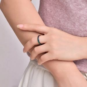 Detailed close-up of a rotating rainbow titanium steel ring with textured diagonal patterns