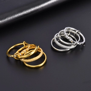 Detailed view of layered titanium steel rings with diamond pavé and frosted textures