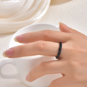 Close-up of black rotatable ring with diagonal textured edges on titanium steel
