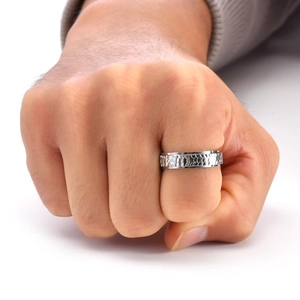 Detail of silver spinner ring featuring unique hand-hammered honeycomb texture on male hand