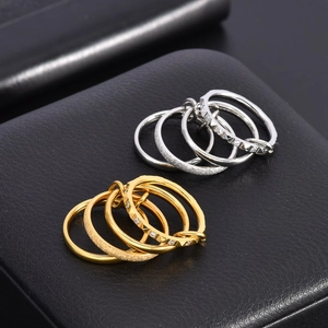 Macro shot of 5-piece 18K gold and silver stacked ring set on black leather background