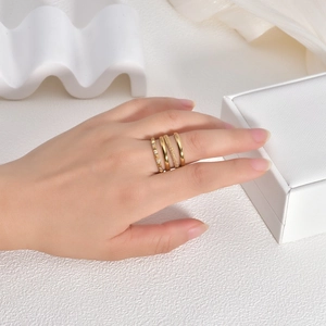 Close-up of set of four 18K gold-plated titanium steel rings with diamond accents