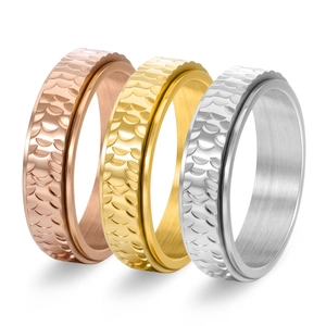 Macro detail of three-piece hammered stainless steel spinner rings in gold, silver, and rose gold
