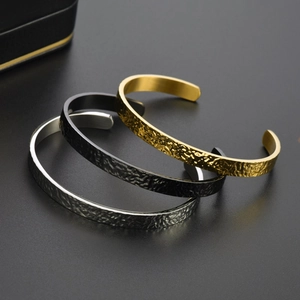 Three-piece hammered stainless steel C-shaped cuff bracelets in gold, black, and silver
