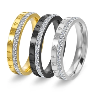 Detail view of 18K gold, black and silver rings with rune symbols and inlaid diamonds