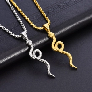 Dettaglio dei ciondoli a serpente oro e argento con scaglie su pelle nera