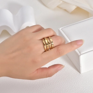 Detail of stacked 18K gold titanium rings with Roman numerals and inlaid zircon stones