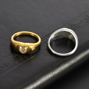 Detailed macro view of heart-shaped signet rings in gold with zircon and silver finishes