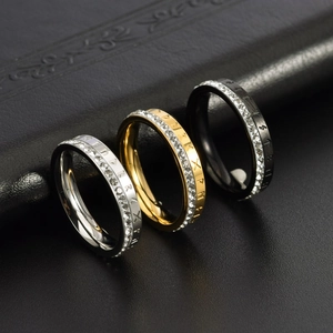 Macro detail of three rune rings in silver, gold, and black with pave crystals