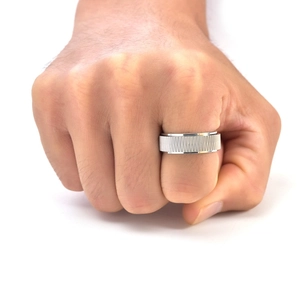 Detail of silver men's rotatable titanium steel ring with industrial vertical twill texture