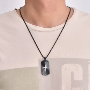 Nahaufnahme des schwarzen rechteckigen Dog-Tag-Anhängers mit Strass-Kreuz und Perlenkette