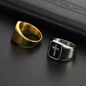 Detail view of gold brushed ring and silver ring with black enamel cross on leather