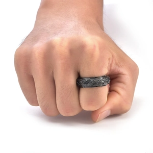 Detail of black spinner ring for men with vintage thorn vine pattern on finger