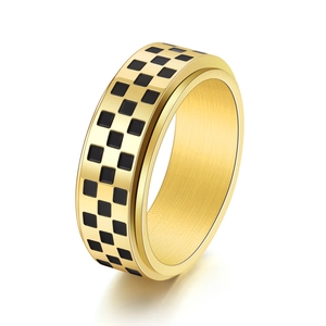 Detail of golden spinner ring with black checkered pattern in polished stainless steel