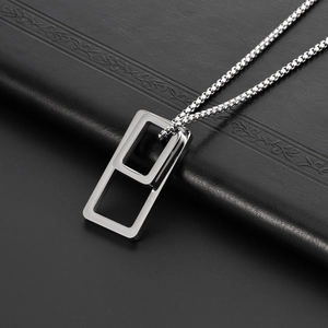 Collier à double pendentif rectangulaire en acier titane avec chaîne box sur fond noir