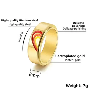 Macro detail of 8mm gold spinner ring showing colorful enamel heart and polished steel finish
