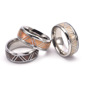 Macro view of men's geometric titanium rings with inlaid wood texture and triangle pattern