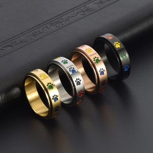 Anelli rotanti arcobaleno in quattro colori con impronte di zampe colorate su nero
