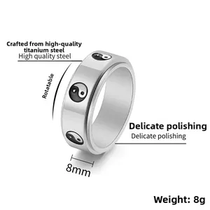 Macro detail of rotating silver titanium steel ring with black and white Tai Chi symbol