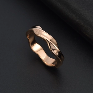 Macro shot of rose gold Mobius ring with high-polished lava waves and organic fluid lines