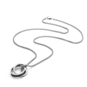 Macro detail of interlocking rings with engraved love text on silver box chain