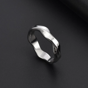 Macro detail of polished Mobius ring with liquid metal wave design on black background