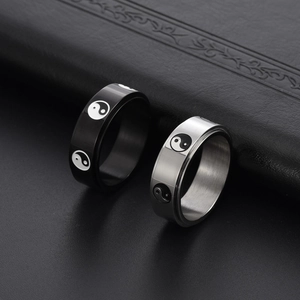 Rotating stainless steel Yin Yang rings in black and silver finish on leather display