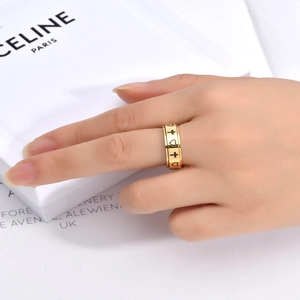 Close-up of gold spinning ring featuring engraved black heart and cross patterns