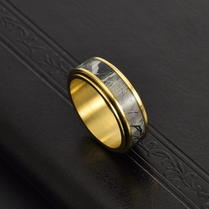 Macro detail of golden rotatable ring with a tree branch pattern on black leather