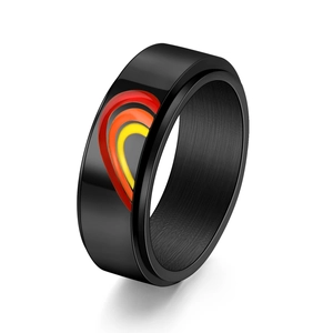 Macro view of a black spinner ring featuring a colorful rainbow heart pattern and smooth finish