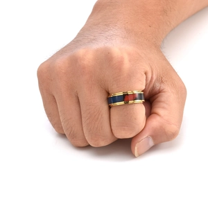 Detail of a rotating gold stainless steel ring with wood grain inlay on a person's hand