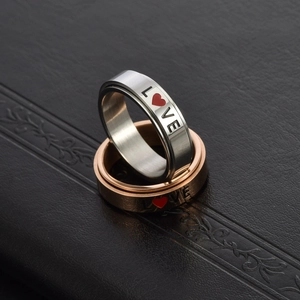 Macro detail of rotating stainless steel LOVE rings in silver and rose gold finishes
