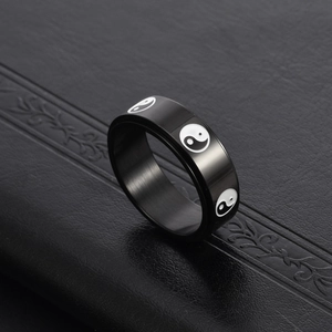 Macro shot of rotatable black titanium steel ring with Yin Yang Tai Chi symbols