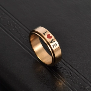 Macro view of rotating rose gold stainless steel ring with LOVE text and red heart engraving