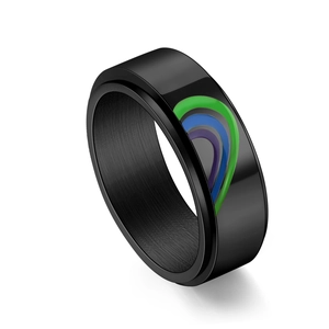 Macro shot of black spinner ring featuring rainbow enamel heart and polished inner finish