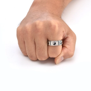 Close-up of a rotating stainless steel ring with black and white Tai Chi Yin Yang symbols