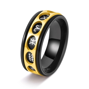 Rotating stainless steel zodiac ring in black and gold with hollow constellation symbols
