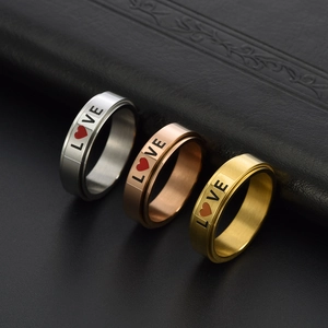 Detailed view of silver, gold and rose gold stainless steel spinning rings with LOVE text