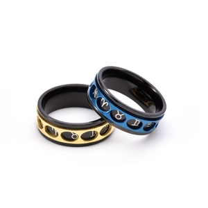Detail of rotatable stainless steel rings with hollowed zodiac signs in gold and blue