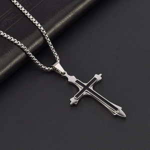 Detailed macro view of a silver stainless steel double cross pendant with black enamel inlay