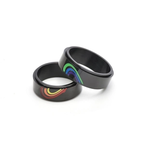 Detail of black stainless steel spinning rings showing a split rainbow enamel heart pattern