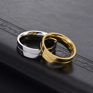 Makroaufnahme von minimalistischen Gold- und Silber-Titanringen auf schwarzem Lederhintergrund