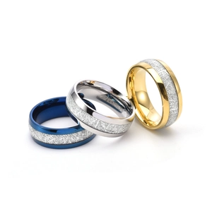 Detail of 8mm titanium rings in blue, gold and silver with meteorite texture inlay