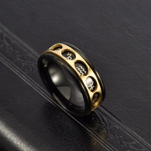 Macro view of rotating black stainless steel ring with golden zodiac symbols engraved