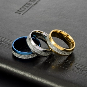 Three minimalist titanium steel rings with crushed texture in blue, silver, and gold finish